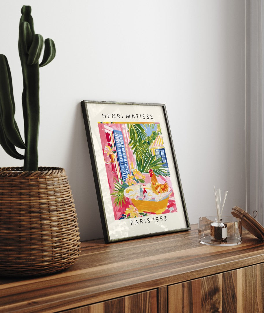 Framed wall art of a rooster in a bright bath scene, surrounded by tropical leaves and vibrant color, in the style of Henri Matisse.