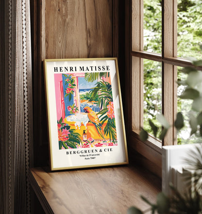 Framed Henri Matisse inspired print featuring a colorful parrot in a tropical bathroom scene with a yellow tub and seaside view.