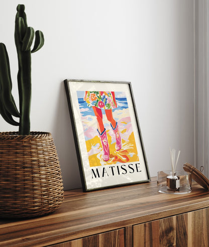 Framed art print featuring pink cowboy boots and floral dress at the ocean in bold Matisse style