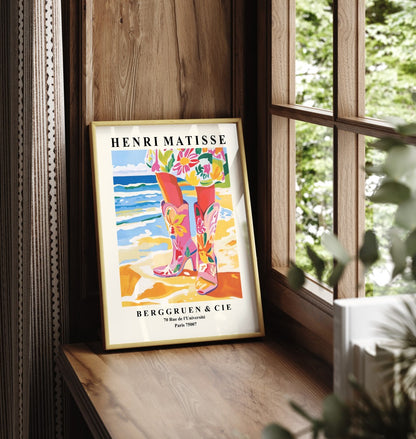 Framed art print showing floral cowgirl boots standing on sandy seaside