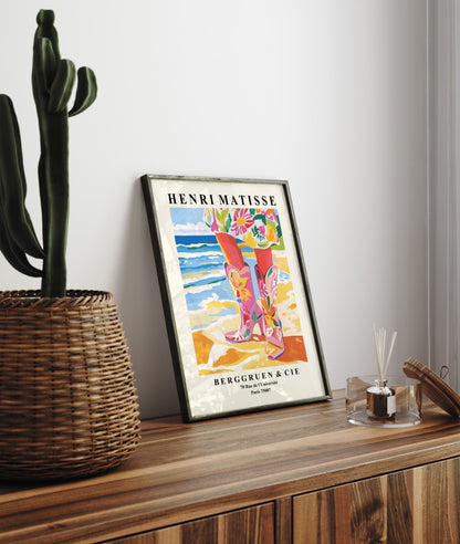 Framed coastal cowgirl art print featuring floral boots and shoreline in colorful Matisse style