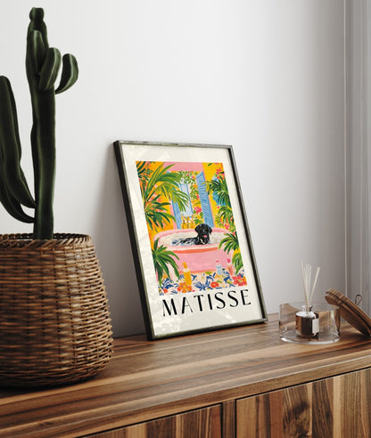 Framed artwork of a black Labrador relaxing in a lush, plant-filled setting.