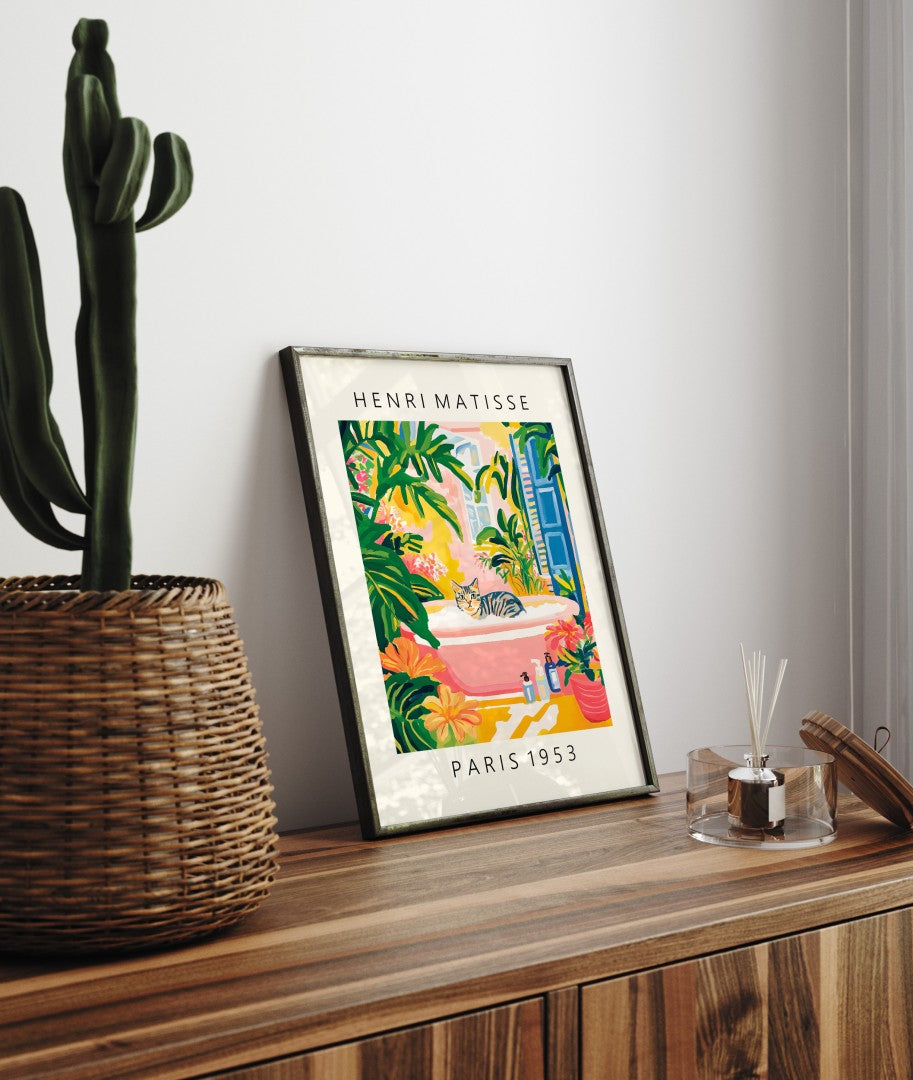 Framed cat art print for bathroom walls with a pink tub and vivid plants.