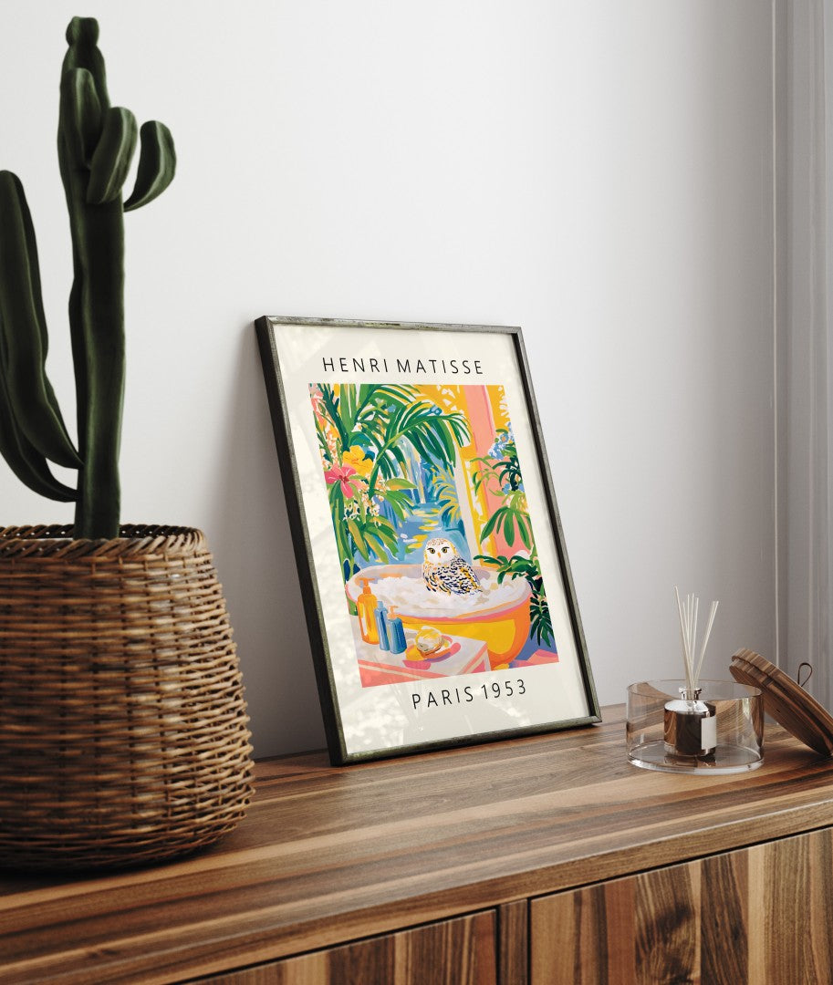 Framed bathroom art print of a snowy owl in bathtub surrounded by greenery