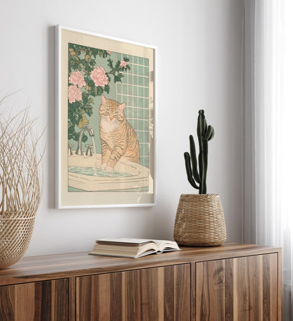 Framed artwork of a cat at a sink on a wall above a wooden cabinet with decor items.