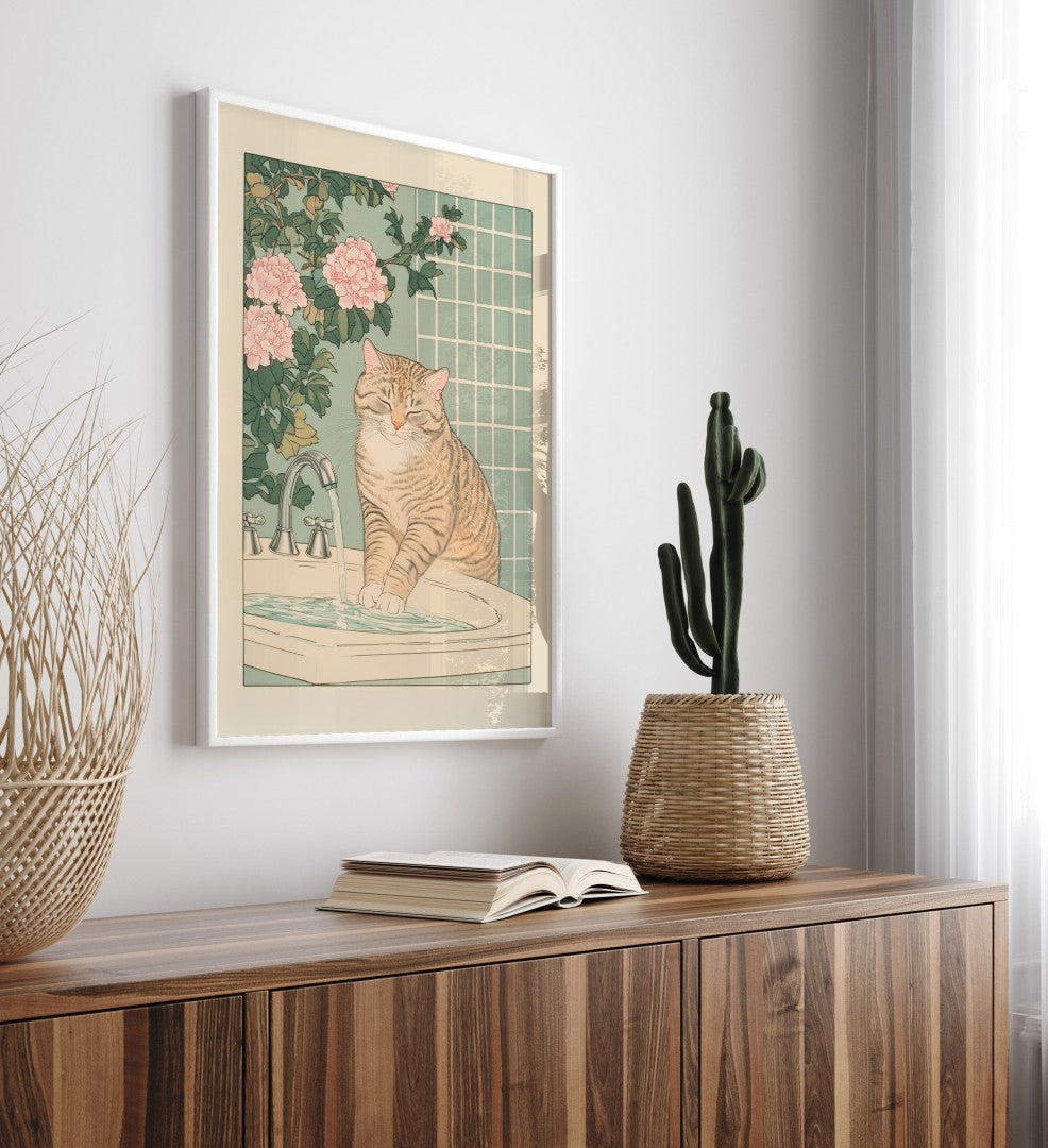 Framed artwork of a cat at a sink on a wall above a wooden cabinet with decor items.